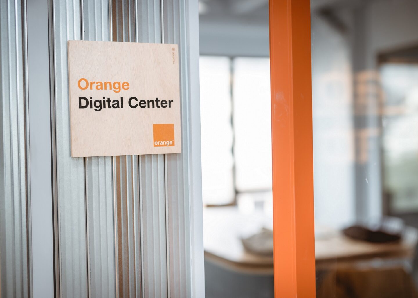 An illustrative picture showing the door of our Orange Digital Center, with a small wooden panel with its name written on it.